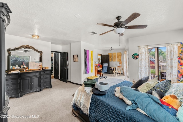 bedroom with light colored carpet, a textured ceiling, a ceiling fan, and baseboards