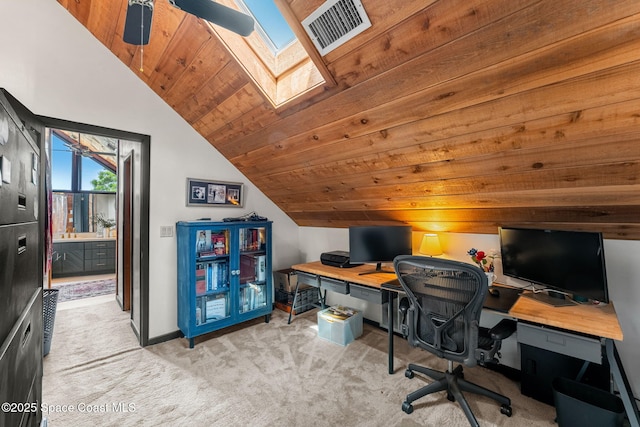 office space featuring vaulted ceiling, light colored carpet, wooden ceiling, a skylight, and baseboards