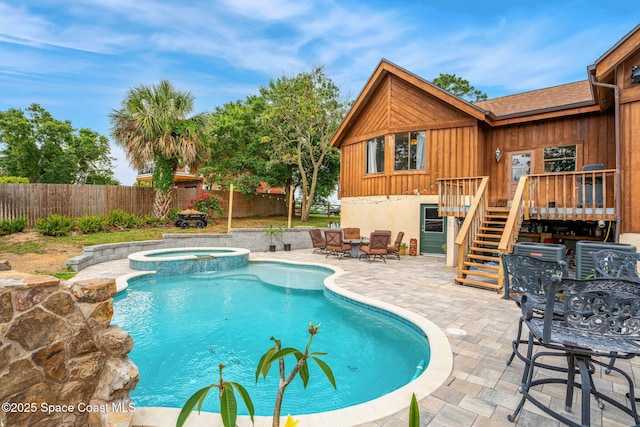 view of pool with a fenced backyard, stairway, a patio area, a wooden deck, and outdoor dining area