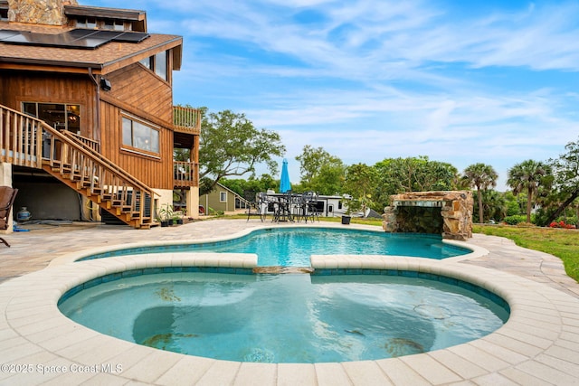 view of pool with a pool with connected hot tub, stairway, a patio, and outdoor dining space