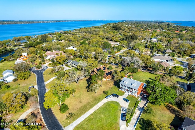 aerial view of property and surrounding area featuring a nearby body of water and nearby suburban area