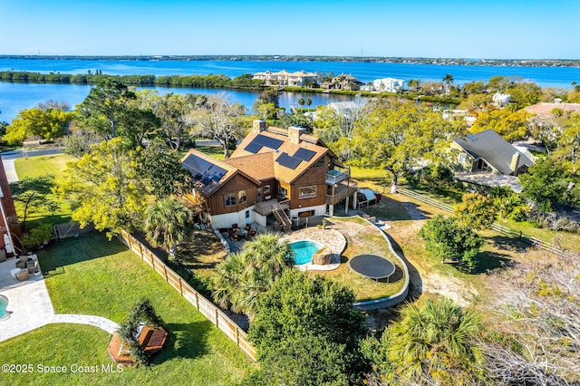 aerial view of property and surrounding area featuring a pool area and a nearby body of water