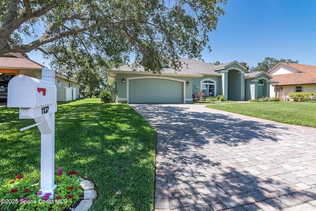 1132 Cypress Trace Dr, Melbourne, FL 32940 - view of front of house featuring stucco siding, decorative driveway, a garage, and a front lawn