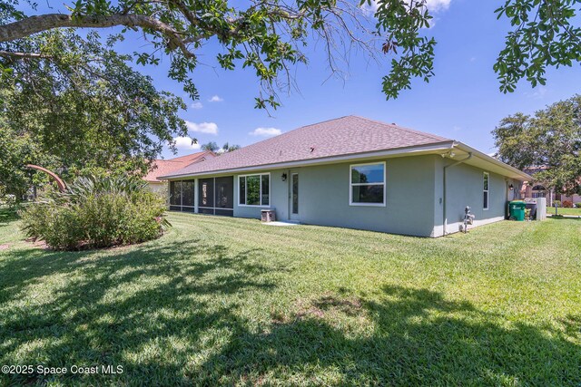 1132 Cypress Trace Dr, Melbourne, FL 32940 - back of property with a sunroom, stucco siding, a lawn, and a shingled roof