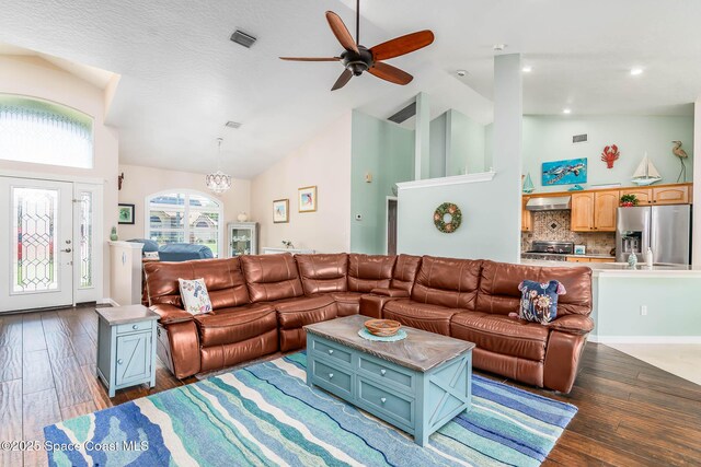 1132 Cypress Trace Dr, Melbourne, FL 32940 - living area featuring high vaulted ceiling, wood finished floors, a ceiling fan, and a chandelier