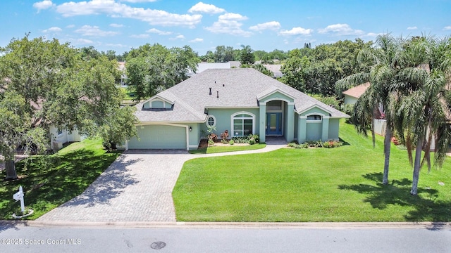 1132 Cypress Trace Dr, Melbourne, FL 32940 - mediterranean / spanish house with an attached garage, decorative driveway, a front yard, stucco siding, and a shingled roof