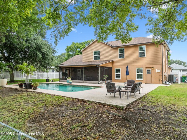 2449 Willowbrook Rd, Merritt Island, FL 32952 - back of house with a sunroom, a patio, cooling unit, a shingled roof, and an outdoor hangout area