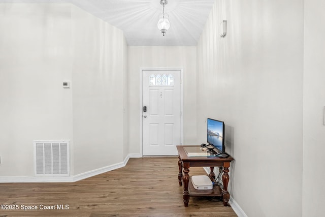doorway featuring wood finished floors and baseboards