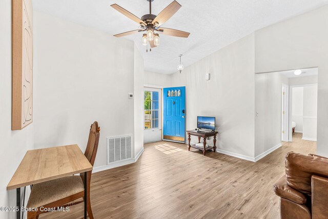 foyer entrance with wood finished floors, ceiling fan, and baseboards