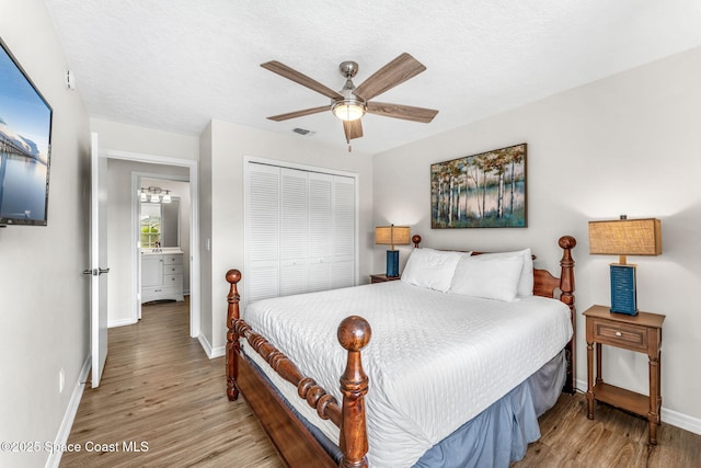 bedroom featuring a closet, wood finished floors, baseboards, and ceiling fan