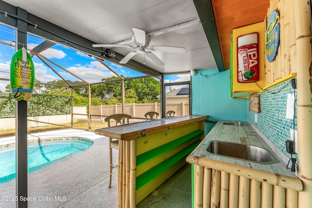 view of pool featuring a lanai, a patio, fence, and a sink