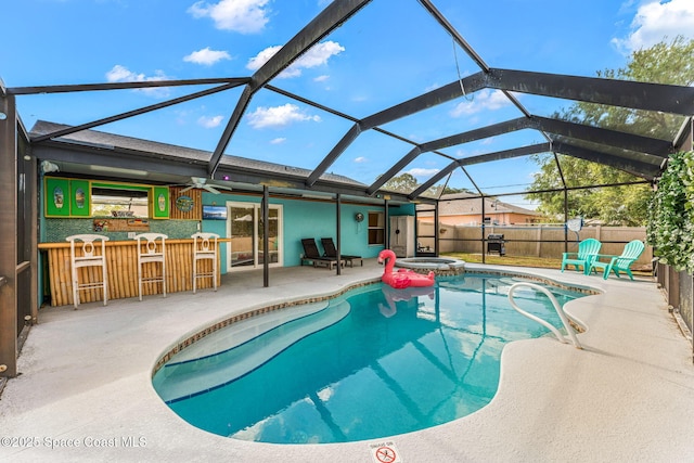 view of pool featuring a patio area, a lanai, and a pool with connected hot tub