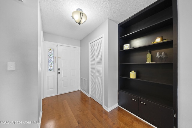 255 S Tropical Trl Unit B3, Merritt Island, FL 32952 - foyer entrance featuring wood finished floors, baseboards, and a textured ceiling