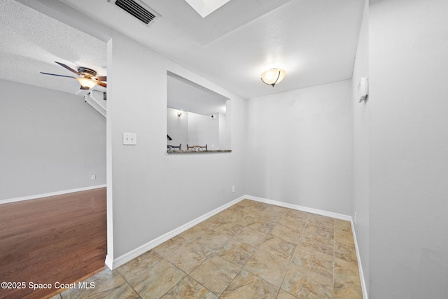 255 S Tropical Trl Unit B3, Merritt Island, FL 32952 - spare room with baseboards, a skylight, and a ceiling fan