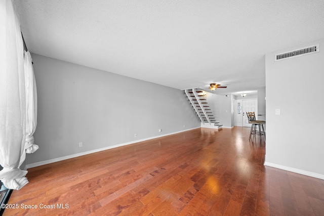 255 S Tropical Trl Unit B3, Merritt Island, FL 32952 - unfurnished living room with stairway, wood finished floors, ceiling fan, and baseboards