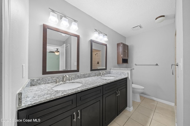 255 S Tropical Trl Unit B3, Merritt Island, FL 32952 - bathroom featuring double vanity, toilet, tile patterned flooring, and a textured ceiling