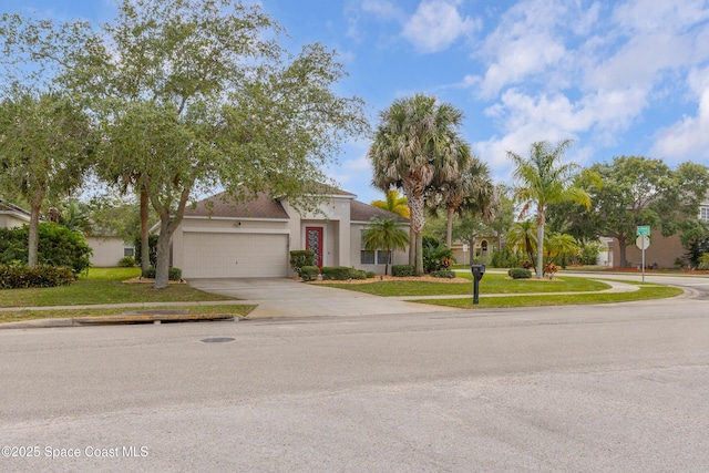 view of front of house featuring driveway, an attached garage, stucco siding, and a front yard