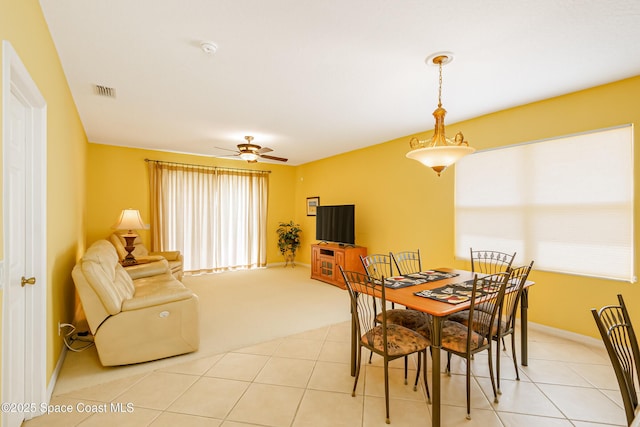 dining space with light tile patterned floors, a ceiling fan, and baseboards