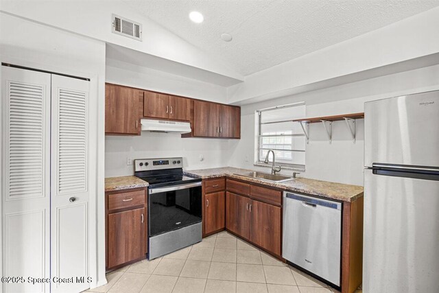 326 Brescia St NE, Palm Bay, FL 32907 - kitchen featuring stainless steel appliances, a sink, under cabinet range hood, vaulted ceiling, and light tile patterned floors