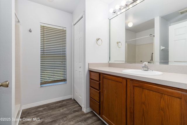 5230 Everett St, Cocoa, FL 32927 - full bathroom featuring wood finished floors, vanity, a shower, and baseboards