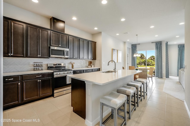 2679 Avalonia Dr, Melbourne, FL 32940 - kitchen featuring stainless steel appliances, tasteful backsplash, an island with sink, light countertops, and light tile patterned flooring