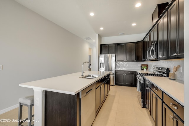 2679 Avalonia Dr, Melbourne, FL 32940 - kitchen featuring appliances with stainless steel finishes, backsplash, light countertops, a kitchen island with sink, and recessed lighting