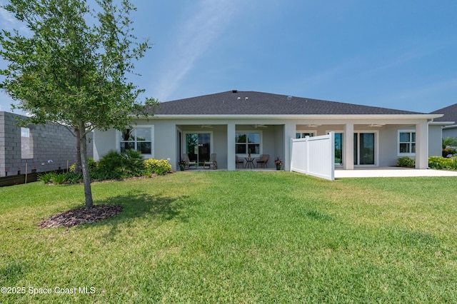 2679 Avalonia Dr, Melbourne, FL 32940 - back of property with a ceiling fan, a lawn, a patio area, and stucco siding