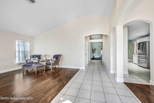 4040 Estancia Way, Melbourne, FL 32934 - sitting room featuring lofted ceiling, arched walkways, light wood-type flooring, and baseboards