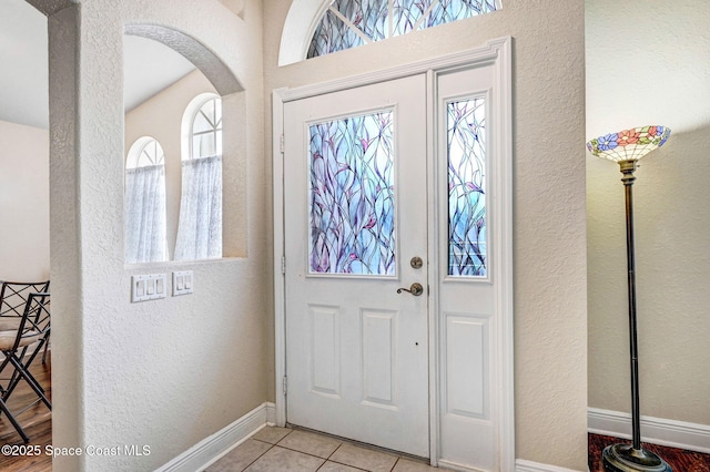 4040 Estancia Way, Melbourne, FL 32934 - tiled entrance foyer featuring a textured wall, baseboards, and arched walkways