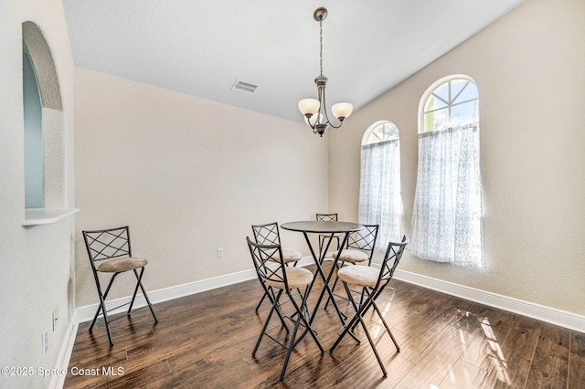 4040 Estancia Way, Melbourne, FL 32934 - dining area with a chandelier, baseboards, wood finished floors, and vaulted ceiling