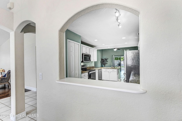4040 Estancia Way, Melbourne, FL 32934 - kitchen featuring appliances with stainless steel finishes, light tile patterned floors, arched walkways, white cabinetry, and recessed lighting