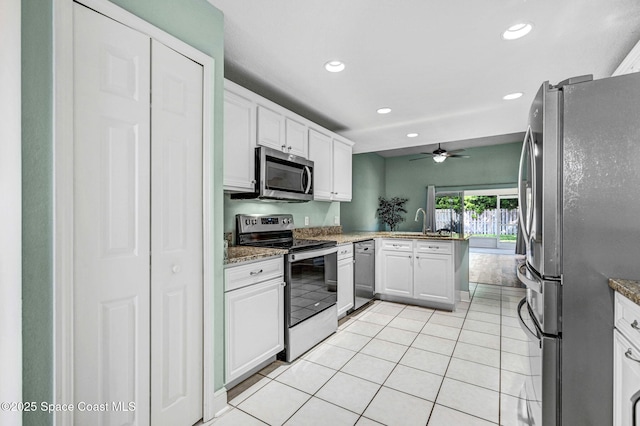 4040 Estancia Way, Melbourne, FL 32934 - kitchen with stainless steel appliances, recessed lighting, light tile patterned flooring, white cabinets, and a peninsula
