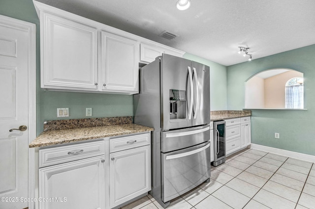 4040 Estancia Way, Melbourne, FL 32934 - kitchen featuring stainless steel refrigerator with ice dispenser, white cabinets, beverage cooler, light tile patterned flooring, and a textured ceiling