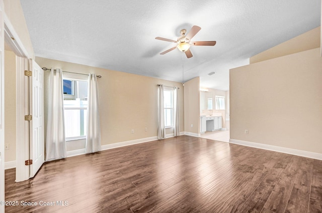 4040 Estancia Way, Melbourne, FL 32934 - unfurnished living room featuring ceiling fan, lofted ceiling, wood finished floors, baseboards, and a textured ceiling