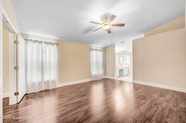 4040 Estancia Way, Melbourne, FL 32934 - unfurnished living room with vaulted ceiling, ceiling fan, wood finished floors, baseboards, and a textured ceiling