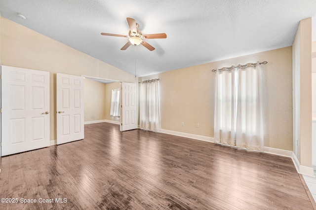 4040 Estancia Way, Melbourne, FL 32934 - unfurnished bedroom with a textured ceiling, lofted ceiling, wood finished floors, baseboards, and ceiling fan