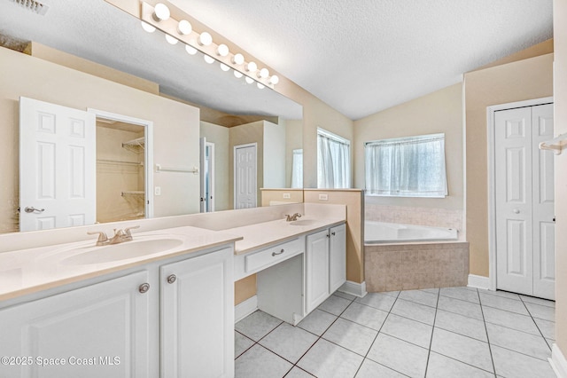 4040 Estancia Way, Melbourne, FL 32934 - bathroom with a textured ceiling, vaulted ceiling, tile patterned floors, double vanity, and a bath