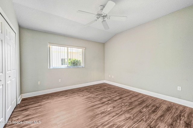 4040 Estancia Way, Melbourne, FL 32934 - unfurnished bedroom with a closet, wood finished floors, baseboards, vaulted ceiling, and ceiling fan