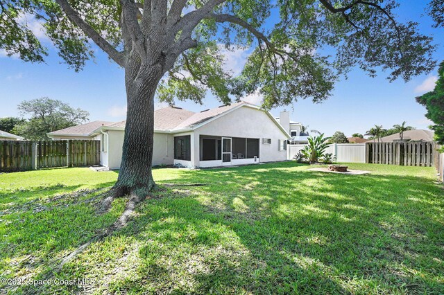 4040 Estancia Way, Melbourne, FL 32934 - back of house featuring stucco siding, a sunroom, and a fire pit