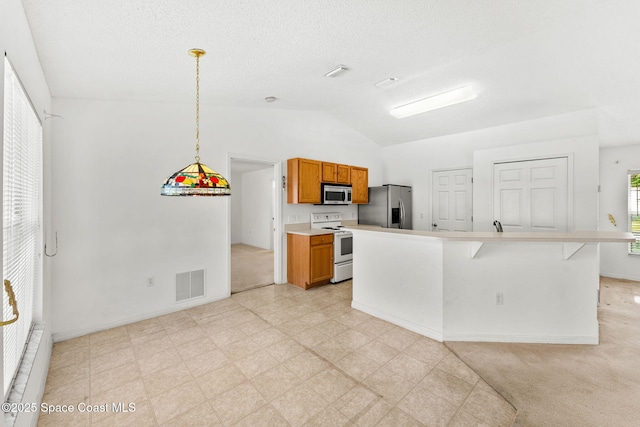 701 Agena Ave NW, Palm Bay, FL 32907 - kitchen featuring stainless steel appliances, lofted ceiling, brown cabinets, light countertops, and decorative light fixtures