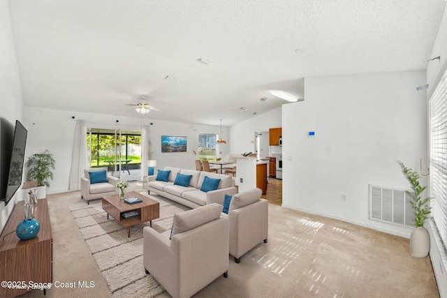 701 Agena Ave NW, Palm Bay, FL 32907 - living room featuring light colored carpet, plenty of natural light, ceiling fan, vaulted ceiling, and a textured ceiling