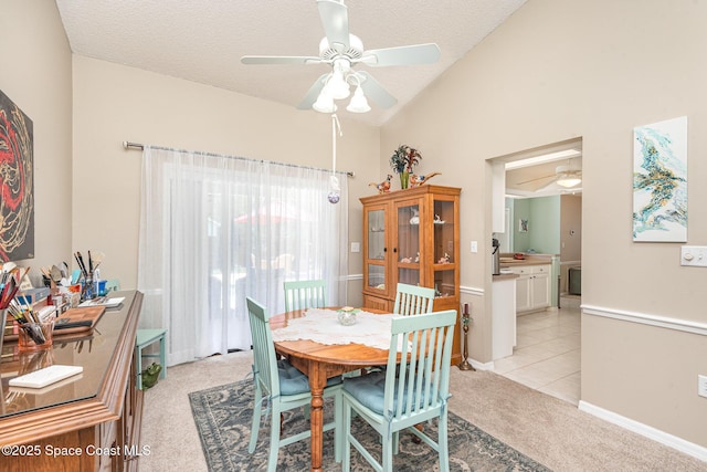 dining area featuring ceiling fan, light colored carpet, vaulted ceiling, a textured ceiling, and baseboards
