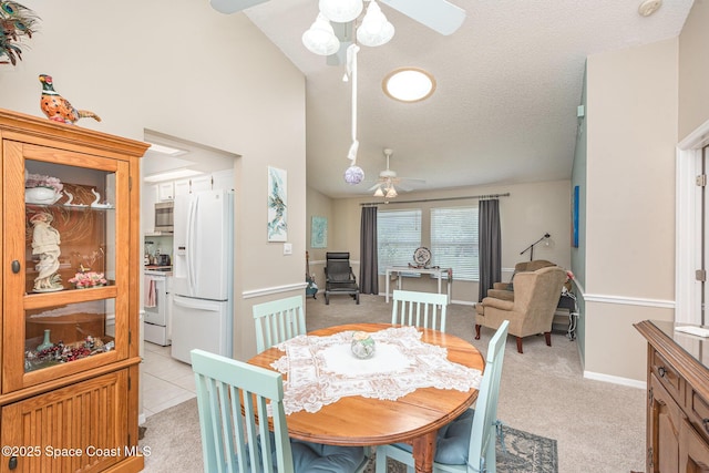 dining room featuring ceiling fan, light colored carpet, lofted ceiling, baseboards, and a textured ceiling
