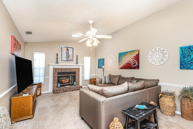 living room featuring ceiling fan, light colored carpet, a brick fireplace, a textured ceiling, and lofted ceiling