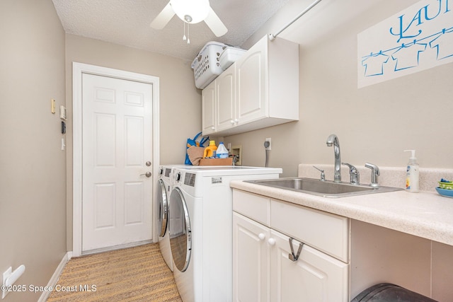 washroom with cabinet space, washer and dryer, ceiling fan, baseboards, and a textured ceiling