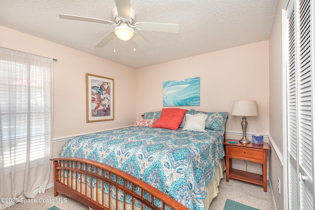 bedroom featuring carpet flooring, a closet, baseboards, a textured ceiling, and a ceiling fan