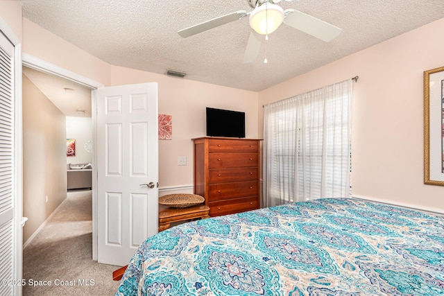 bedroom featuring carpet, a textured ceiling, and a ceiling fan