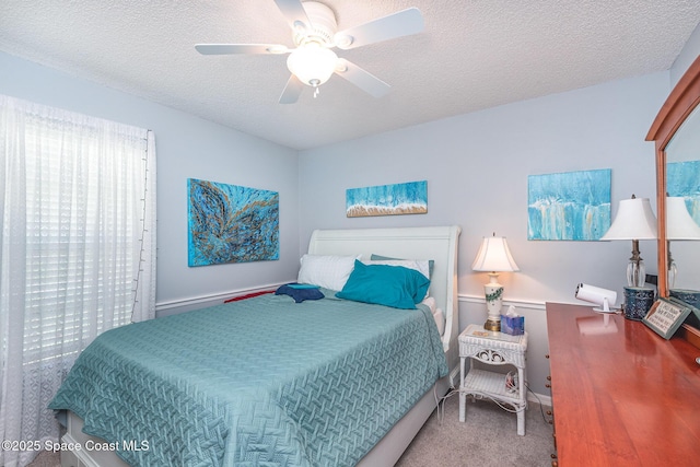 carpeted bedroom featuring a textured ceiling and a ceiling fan