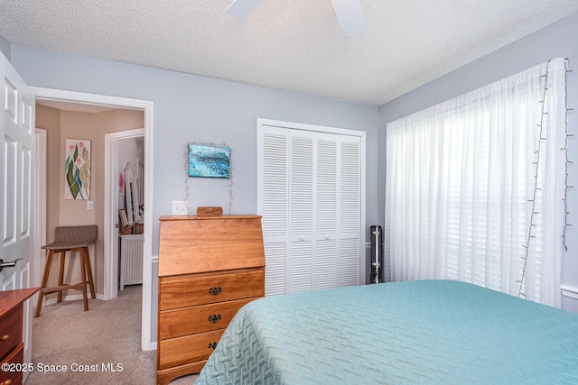 bedroom with a closet, carpet, a textured ceiling, and ceiling fan