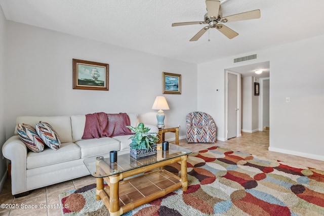 living room featuring tile patterned flooring, a ceiling fan, and baseboards